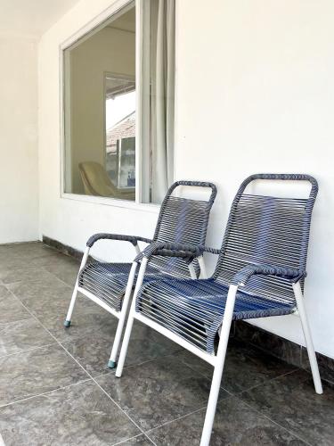 two chairs sitting on a porch in front of a window at Kasih HomeStay Banyuwangi Mount Ijen Crater in Banyuwangi