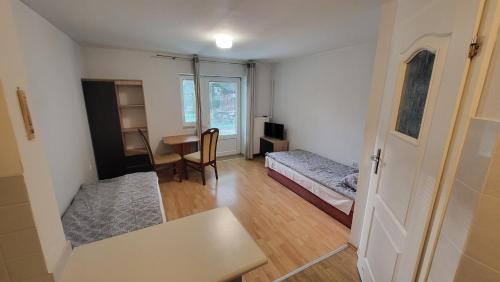 a small room with a bed and a desk and a table at Rozalia in Wisełka