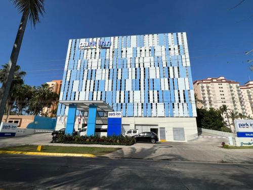 a tall building with a car parked in front of it at Park Inn by Radisson Mazatlan in Mazatlán