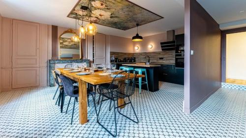 une salle à manger avec une table et des chaises en bois dans l'établissement La maison du moussec, aux Riceys