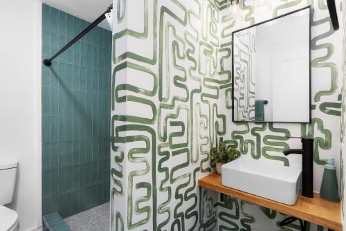 a bathroom with a green and white patterned shower curtain at Motel Miya in Rockport