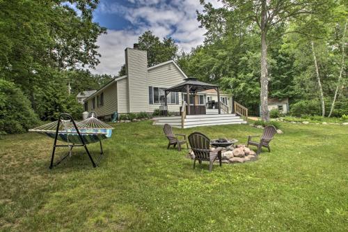 a yard with chairs and a house at New Hampshire Home with Private Beach, Dock and Rafts! in Barnstead