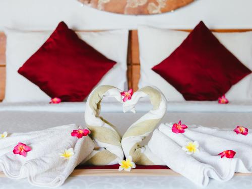 two towels in the shape of swans on a plate at Villa Olala Penida in Toyapakeh