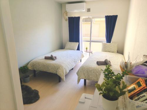 a small room with two beds and a window at MaMe Inn, - Vacation STAY 72934v in Saitama