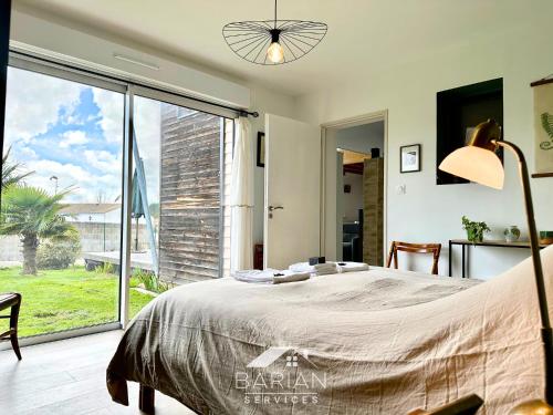 une chambre avec un lit et une grande fenêtre dans l'établissement Maison en bois 6p à 5km des plages de Fouras, à Saint-Laurent-de-la-Prée