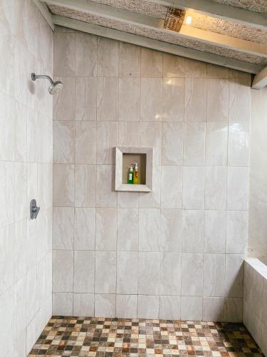 a bathroom with a shower with a tile wall at Villa Olala Penida in Toyapakeh
