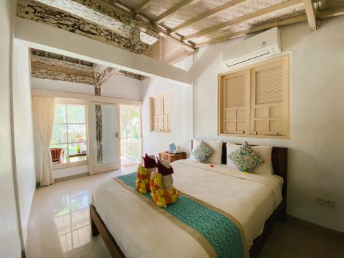 a bedroom with a bed with two rubber boots on it at Villa Olala Penida in Toyapakeh