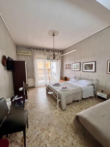 a bedroom with a large bed and a chandelier at LG Appartamento Turistico Giarre in Giarre