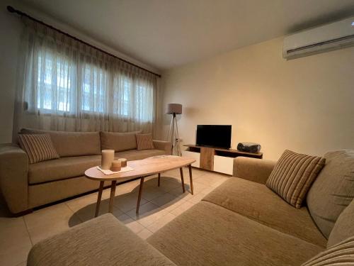 een woonkamer met twee banken en een tafel bij Joanna's House in Néa Péramos