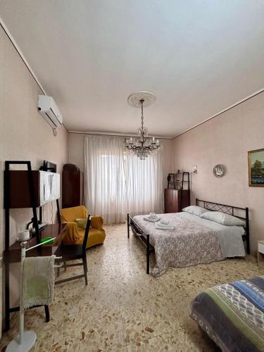 a bedroom with a bed and a chandelier at LG Appartamento Turistico Giarre in Giarre