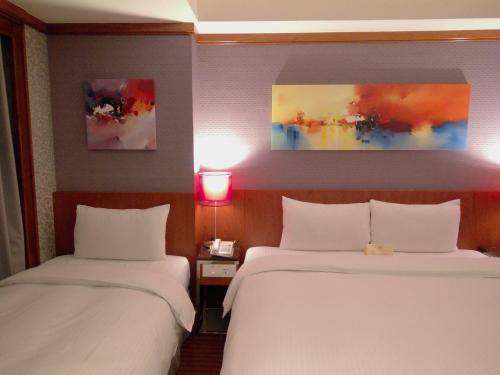 a hotel room with two beds and a lamp at Beauty Hotels Taipei - Hotel Bchic in Taipei