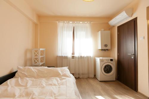 a bedroom with a bed and a washing machine at Studio 24 in Iaşi