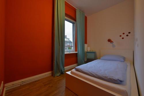 a bedroom with a bed and a window at Townside Hostel Bremen in Bremen