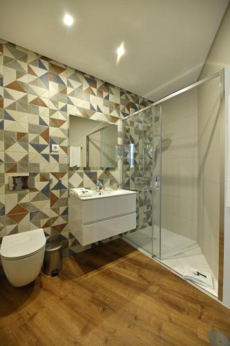 a bathroom with a toilet and a sink and a shower at Alojamento Dias in Tarouca