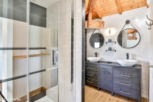 un bagno con due lavandini e due specchi di DOMAINE DE LA PORTE ad Agonac
