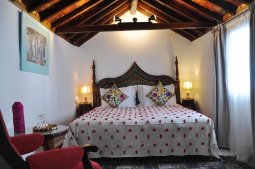 Schlafzimmer mit einem großen Bett mit einem Kopfteil aus Holz in der Unterkunft Riad Cherifa in Chefchaouen