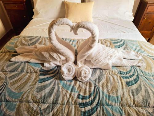 two towel swans making a heart on a bed at Biginau ' e giosso in Ilbono