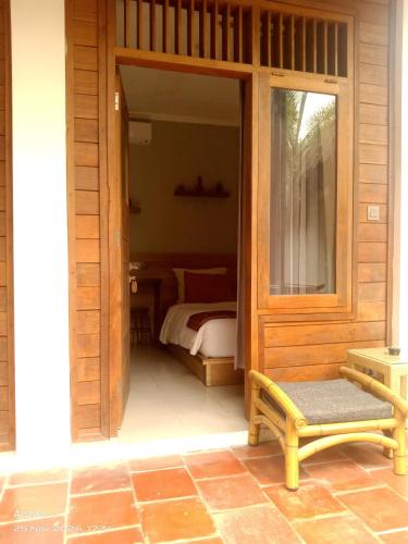 a room with a bedroom with a bed and a bench at Village Vibes Lombok in Kuta Lombok