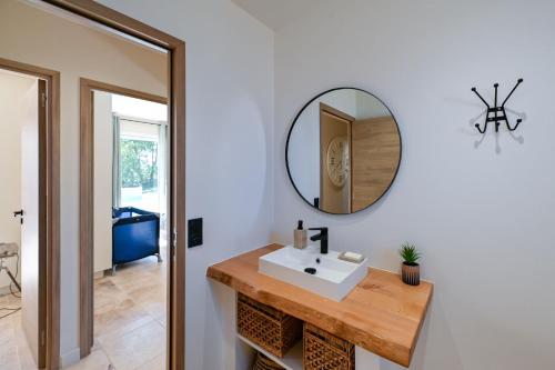 une salle de bain avec un lavabo et un miroir au mur dans l'établissement Le Clos Des Oliviers, à Saint-Privat-de-Champclos
