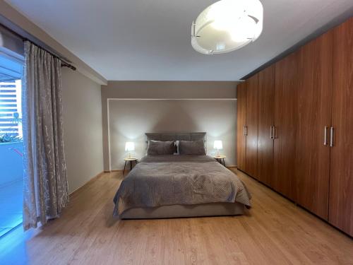 a bedroom with a large bed and wooden cabinets at Garden Retreat Spiranca in Tirana