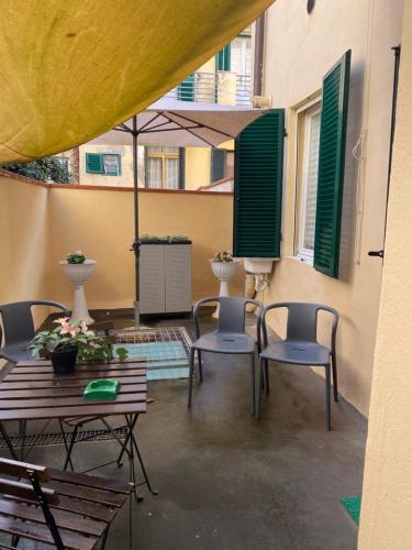 a patio with chairs and tables and an umbrella at Tower Pisa apartment in Pisa