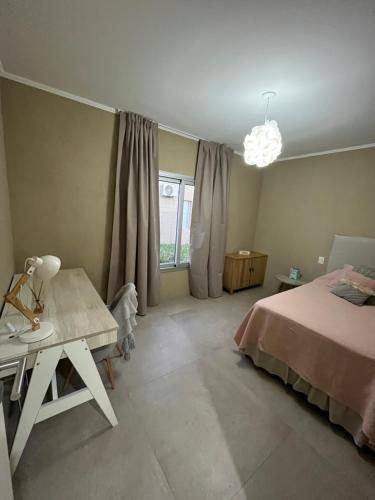 a bedroom with a bed and a table and a window at Casa Quinta in Chivilcoy