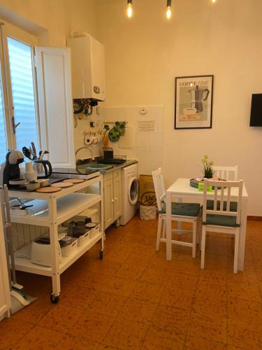 a kitchen with a stove and a table with chairs at Tower Pisa apartment in Pisa