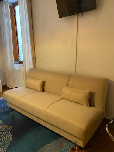 a couch with two pillows on it in a room at Tower Pisa apartment in Pisa