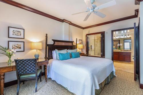 a bedroom with a bed and a desk and a ceiling fan at Waipouli Beach Resort F402 in Wailua