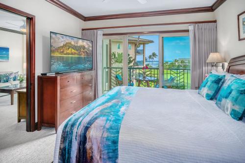 una camera da letto con un letto grande e una televisione di Waipouli Beach Resort F301 a Wailua