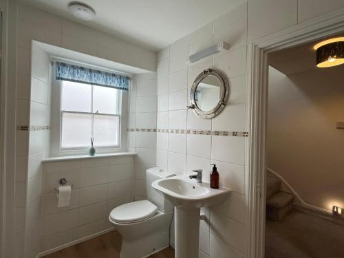 ein weißes Badezimmer mit Toilette und Waschbecken in der Unterkunft The Ferryman in Weymouth