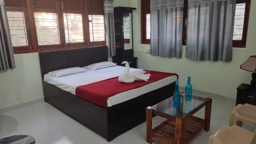 a bedroom with a bed and a table and windows at OTP holiday homes in Kīhīm