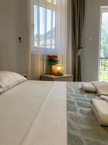 a bedroom with a large white bed with a window at Bybassios Orhaniye in Orhaniye