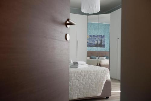 a bedroom with a white bed and a mirror at Casa Lucrezia - alla Torre in Viterbo