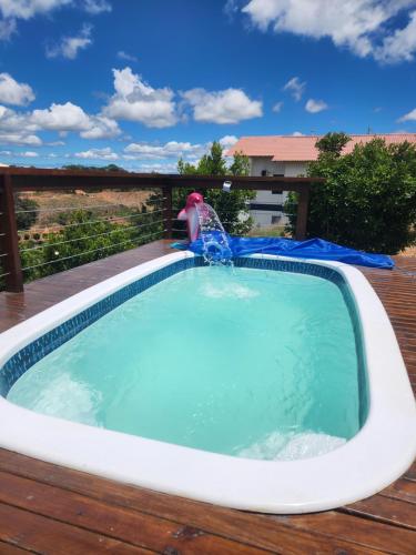 a pool on a deck with a water fountain at Chalé dos Manacás Duplex in Venda Nova do Imigrante
