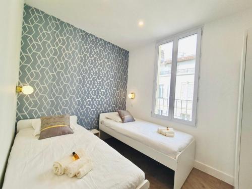 a bedroom with two beds and a window at Luxury 3 bed 2 bath flat Cannes Croisette in Cannes