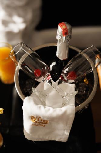 a wine glass and a bottle on a table at Destiny Hotel & SPA in Tirana