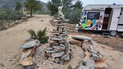 a pile of rocks in a garden next to a rv at WakeTheFUP Holistic Meditation Temple in Mas Boquera