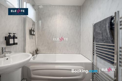 a bathroom with a white tub and a sink and a bath tub at Premium Offers, Last-Minute Escapes, 3 Bedroom House, Free Parking, Sleeps Up to 5, Private Garden, Elevate Living Estates Short Lets & Serviced Apartments Northampton in Spinney Hill