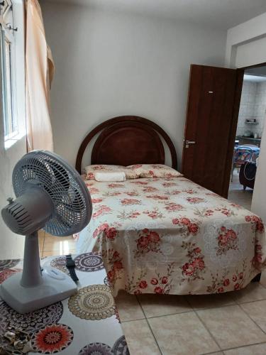 a bedroom with a bed and a fan on the floor at Hospedagem do Marcão in Belo Horizonte