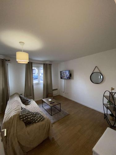 un salon avec un lit et une table dans l'établissement petit appartement cosy, à Noisy-le-Grand