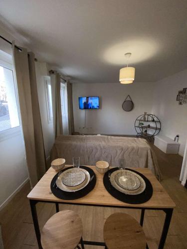 - un salon avec une table et deux assiettes dans l'établissement petit appartement cosy, à Noisy-le-Grand