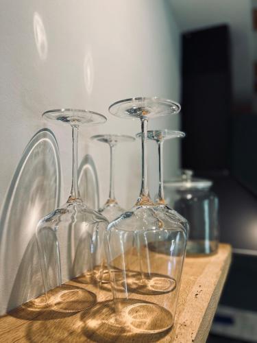 three wine glasses sitting on top of a wooden table at Green Escape Hellendoorn rust & natuur in Hellendoorn