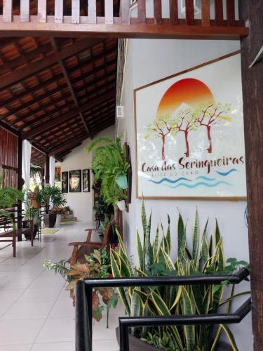 a sign on the side of a building with plants at Casa das Seringueiras in Alter do Chao