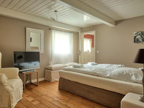 Un dormitorio con una cama y un televisor de pantalla plana. en holiday home with 3 bedrooms, en Wrixum
