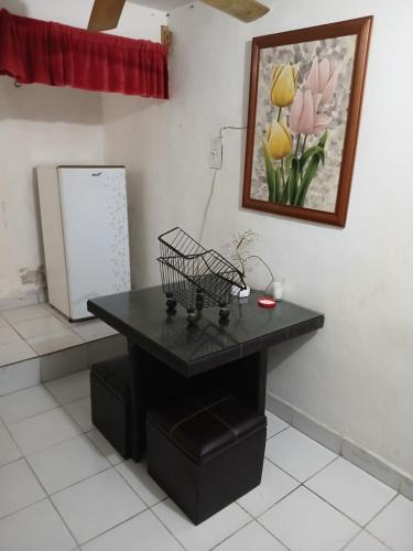 a black table in a kitchen with a refrigerator at Rhinos House in Cozumel