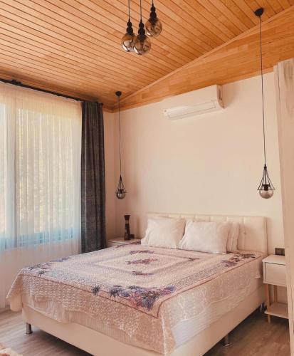 a bedroom with a large bed with a wooden ceiling at Black Cat Villa's in Kemer