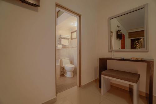 a bathroom with a sink and a toilet and a mirror at Hotel Quirasco in Xalapa