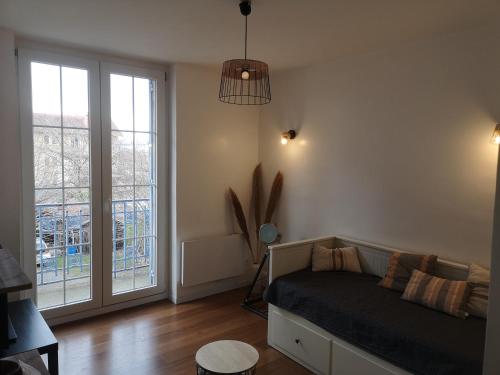 une chambre avec un lit et une grande fenêtre dans l'établissement Le Cosy de Paray 4 couchages, à Paray-le-Monial