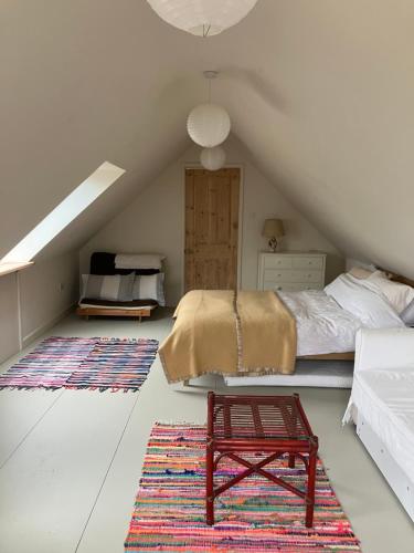 a bedroom with a bed and a stool in a attic at Eaves in Frome